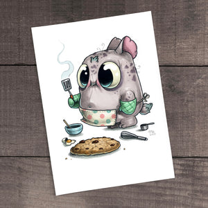 A quirky illustration of an adorable cartoon monster enjoying a Cookie Baker Print cookie and a cup of tea, with a look of content satisfaction on its face, set against a wooden background. This unique piece is inspired by the Chris Ryniak brand.
