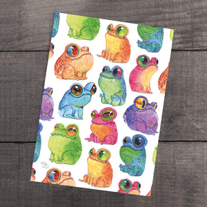 A "Frog Frenzy" print by Chris Ryniak with colorful, whimsical illustrations of cute frogs in various hues and poses, placed on a wooden surface, reminiscent of the style seen in Thimblestump Hollow.