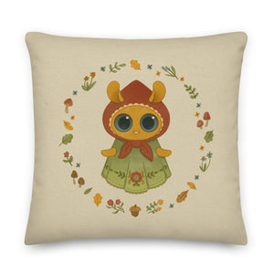 The Bindlewood Shop's Garden Sprite Throw Pillow is a charming rustic addition to any cottagecore interior design. It features a whimsical illustration of a large-eyed Garden Sprite wearing a red hood and green dress adorned with floral patterns. The character is surrounded by a circular arrangement of small flowers, leaves, and mushrooms, making it an enchanting accent piece for your home decor.