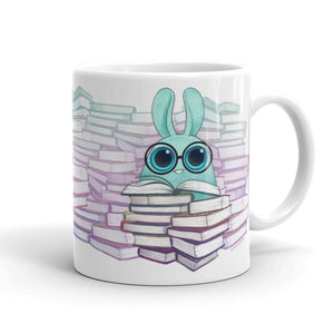 The "So Many Books Mug" from Bindlewood Shop features an adorable blue cartoon rabbit with oversized glasses, surrounded by stacks of vibrant books. Safe for use in both the microwave and dishwasher, this mug's whimsical design adds a cozy, bookish vibe to your everyday routine.