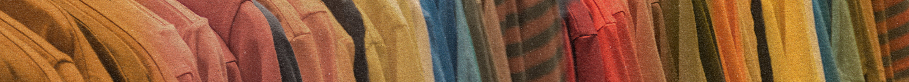 A row of colorful clothes, mainly in shades of brown, orange, yellow, and red, hanging closely together on a rack.