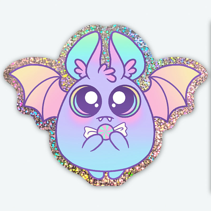 The Glitter Bat Sticker from Bindlewood Shop features a cute cartoon bat with big eyes, pastel colors, and holographic glittery wings, playfully holding a candy—perfect for adding whimsy to your favorite surfaces.