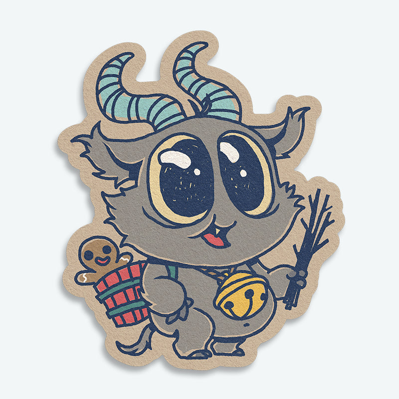The Krampus Sticker from Bindlewood Shop features a cute, chibi goat-like creature with blue striped horns, a big yellow bell, holding twigs, and carrying a basket with a gingerbread man—perfect for adding holiday spirit anywhere!.