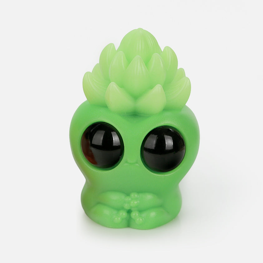Matcha Latte Archie by Chris Ryniak is a small green resin figure with large black eyes, a round body, and a succulent-shaped head, displayed on a plain white background.