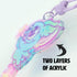 Close-up of Bindlewood Shop's Star Catcher Keychain, a vibrant blue and purple pastel creature. Image text: "TWO LAYERS OF ACRYLIC" with an arrow highlighting the keychain’s thickness.