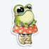 The Toad Stool Sticker from Bindlewood Shop features a cheerful cartoon frog with big eyes atop a grumpy red and white mushroom. With a smooth matte finish, this vinyl sticker brings Chris Ryjniak-inspired charm to any surface.
