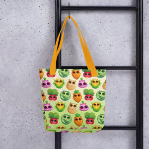 A colorful All the Veggies Tote by Bindlewood Shop with a quirky owl pattern by Amanda Louise Spayd hanging on a black metal ladder against a concrete wall.