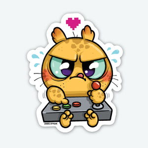 The Bindlewood Shop Gamer Sticker (3-inch) features a cute chubby orange cartoon cat intensely playing an arcade game. Made from durable vinyl with a smooth matte finish, it's perfect for gamers and cat lovers.