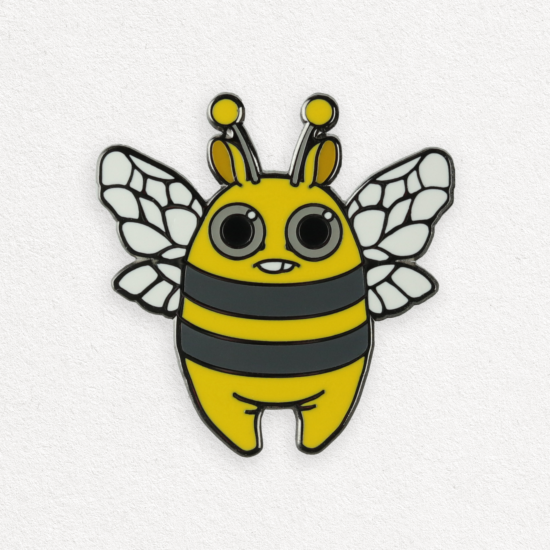 A whimsical, cartoon-style enamel Lemon Bee Pin of a cute "Lemon Bee" character designed by Amanda Louise Spayd, with large eyes and a friendly expression from Bindlewood Shop.
