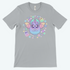 The Bindlewood Shop Pastel Candy Bat Tee is a gray, gender-neutral shirt with a whimsical cartoon bat and playful details like stars, candies, flowers, and ghosts.