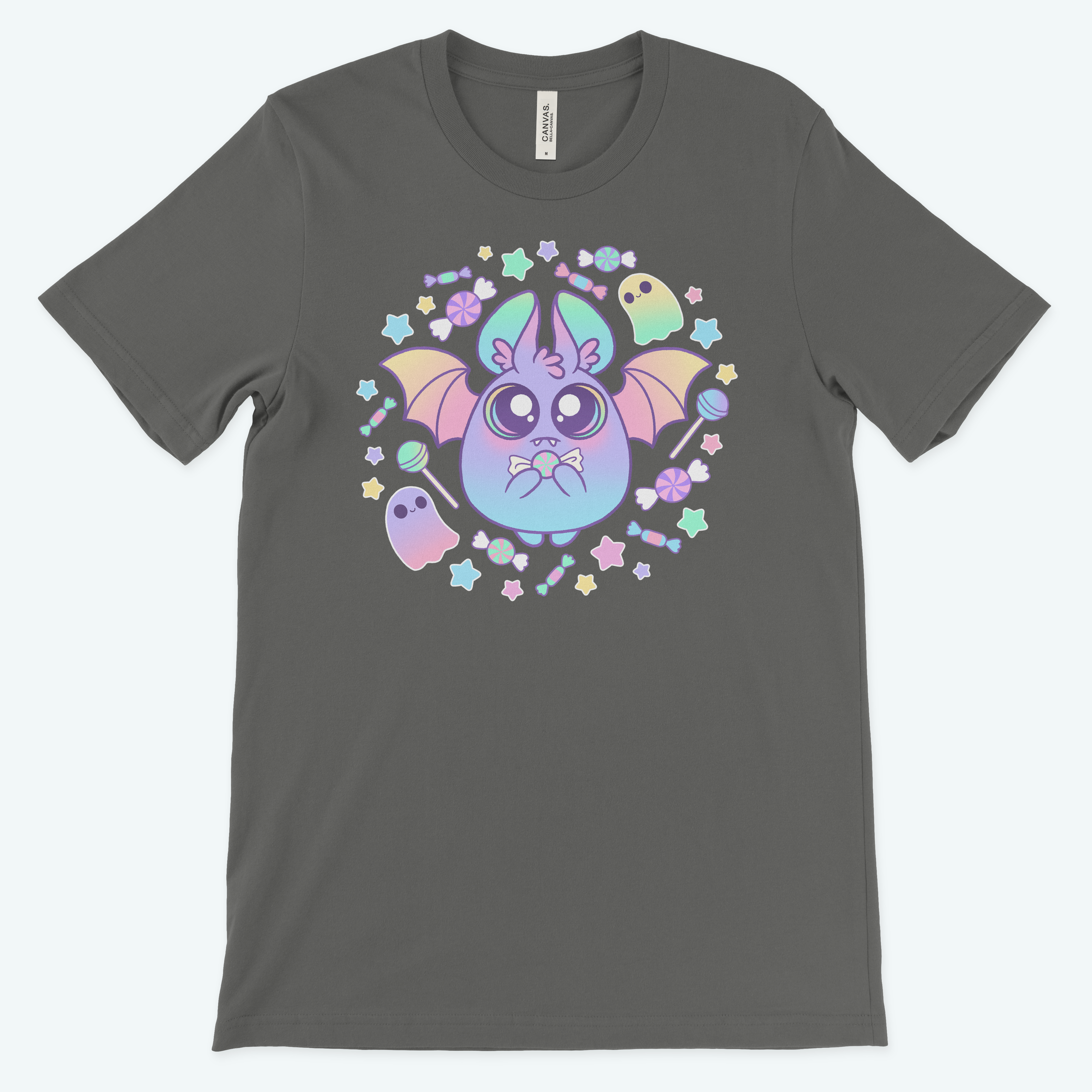 The Pastel Candy Bat Tee from Bindlewood Shop showcases a whimsical illustration of a bat-like creature with colorful wings, surrounded by stars, flowers, and two pastel ghosts on a charcoal-gray t-shirt. Made from pre-shrunk fabric, this vibrant and playful design exudes a mystical vibe with its gender-neutral fit.