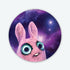 The Pip Galaxy Sticker from Bindlewood Shop features a pink, wide-eyed clay bunny with large blue eyes, gazing upward against a vivid, purple starry galaxy background. This waterproof vinyl sticker is inspired by Amanda Louise Spayd’s creations.