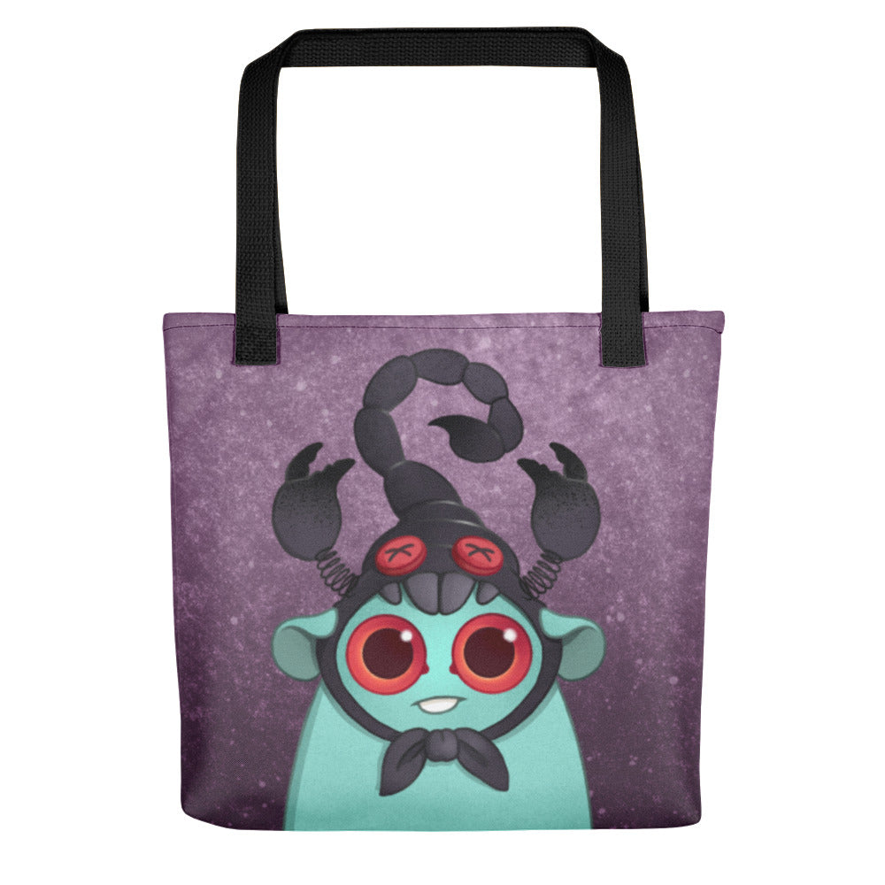 The Bindlewood Shop Scorpio Tote is a durable bag featuring a cartoon creature with big red eyes, teal body, and a black scorpion hat on a purple starry background—perfect for astrology lovers.