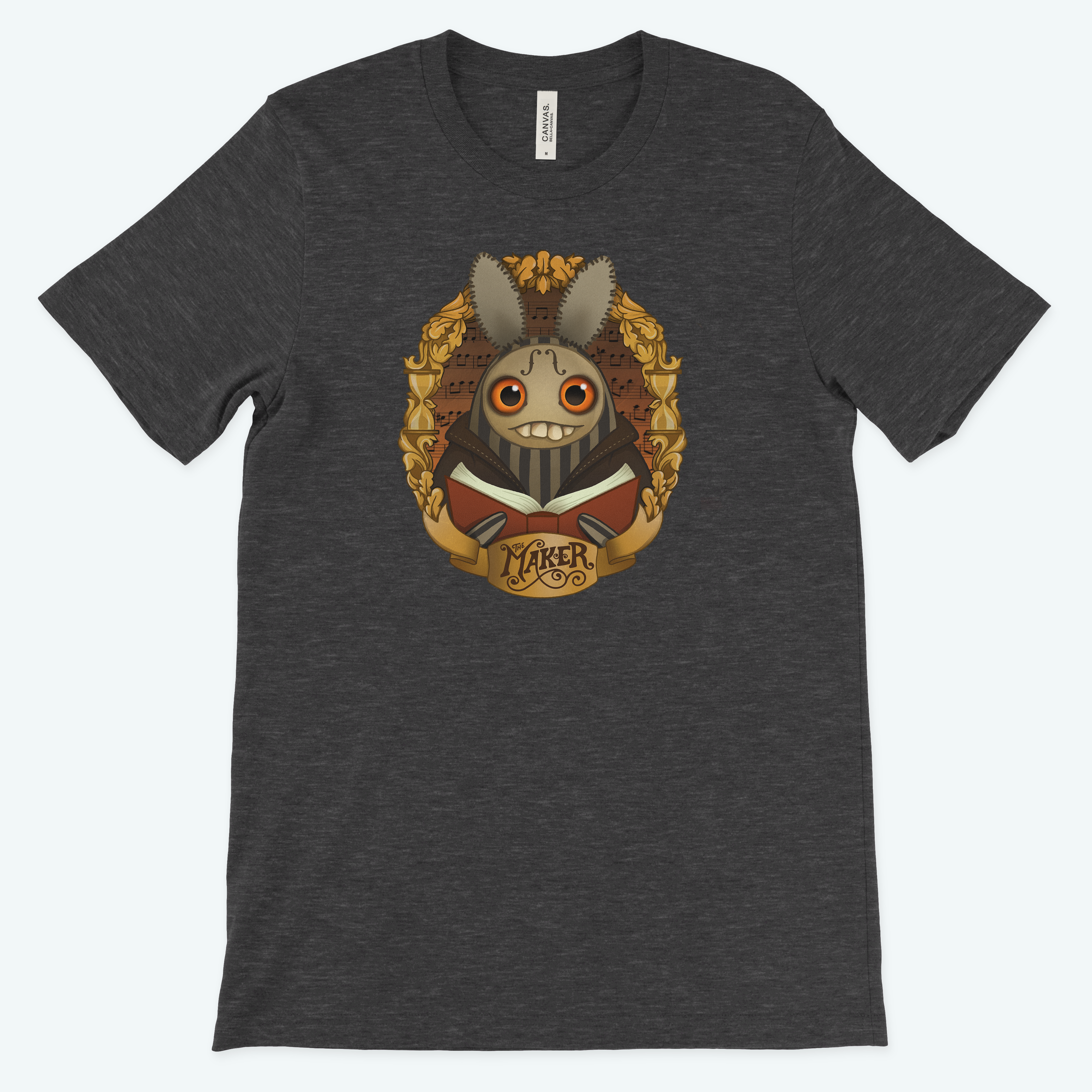 The dark gray tee from Bindlewood Shop features Amanda Louise Spayd's art of a grinning bunny in a gold frame with "The Maker" elegantly inscribed below, including large eyes and a suit.