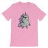 A pink t-shirt featuring a cartoon illustration of a cute, wide-eyed unicorn with a chubby body, small legs, and a purple mane and tail. The Goth Ponycorn Tee from Bindlewood Shop is made from high-quality fabric and has a gender-neutral fit. The unicorn is looking upwards and has a whimsical, endearing expression.
