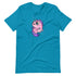 A turquoise t-shirt featuring a whimsical illustration of Chris Ryniak's Flooficorn, a chubby pink unicorn with big eyes, purple mane and tail, and stars around it. The unicorn, standing upright, has spots on its body and appears to be enveloped in bright sparkles. The Bindlewood Shop Floofy Unicorn Magic Tee offers a gender-neutral fit.
