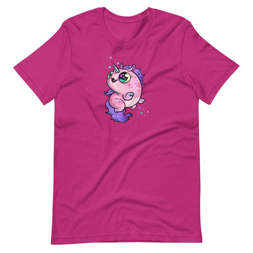 A bright pink, cozy shirt featuring Chris Ryniak's Flooficorn with large green eyes, purple hair, and a chubby body. The gender-neutral fit ensures everyone can enjoy the adorable unicorn floating amidst colorful sparkles. This is the Floofy Unicorn Magic Tee by Bindlewood Shop.