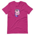A bright pink, cozy shirt featuring Chris Ryniak's Flooficorn with large green eyes, purple hair, and a chubby body. The gender-neutral fit ensures everyone can enjoy the adorable unicorn floating amidst colorful sparkles. This is the Floofy Unicorn Magic Tee by Bindlewood Shop.