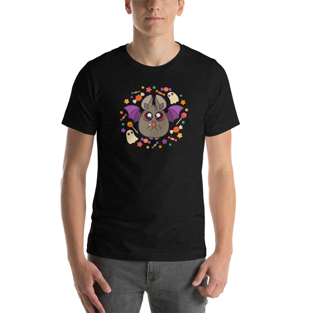 A person is wearing the Candy Bat Tee by Bindlewood Shop, showcasing a cute design of a bat with outstretched wings surrounded by small ghosts and colorful autumn leaves on a black background. The gender-neutral fit ensures comfort for everyone, and each tee is printed to order, perfectly capturing the Halloween spirit. They stand against a plain white background.