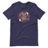 The Candy Bat Tee by Bindlewood Shop is a navy blue t-shirt adorned with a whimsical and playful Halloween-themed design. At its center, it features an adorable cartoon bat with large eyes and purple wings, flanked by two white ghosts and surrounded by small colorful flowers, all set against the shirt's plain dark fabric.