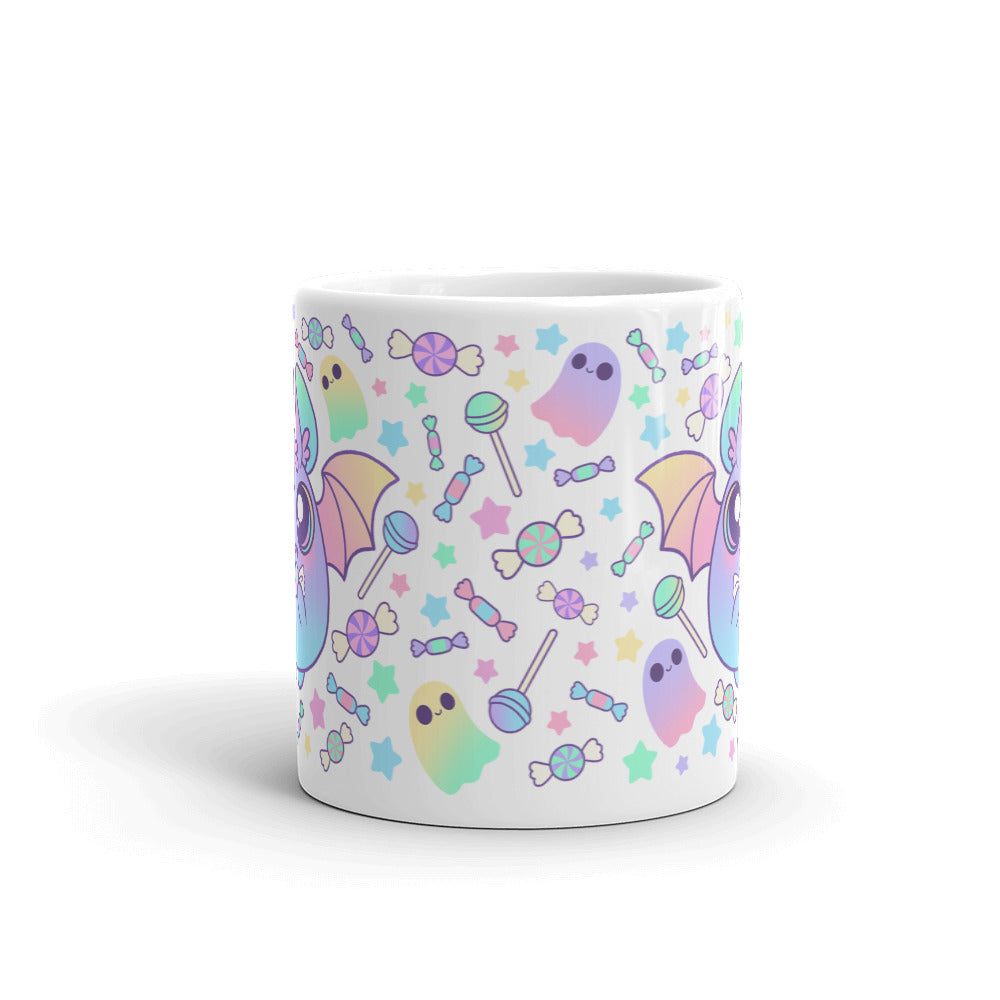 The "Pastel Candy Bat Mug" from Bindlewood Shop is a white ceramic mug adorned with a colorful pattern featuring bats with pastel wings, ghosts, candies, and stars. The design showcases soft pastel shades such as pink, purple, green, and blue, contributing to its whimsical and playful charm. Additionally, it is both microwave safe and dishwasher safe for your convenience.