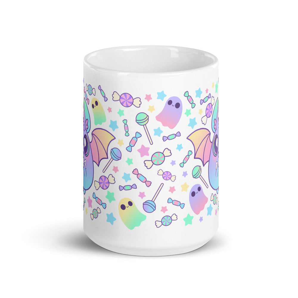 Introducing the Pastel Candy Bat Mug from Bindlewood Shop: a white ceramic mug adorned with vibrant pastel illustrations of adorable bats with wings, playful ghosts, and an assortment of candies such as lollipops and wrapped sweets. The backdrop is embellished with tiny stars in coordinating pastel hues. This mug is both dishwasher safe and microwave safe for your convenience.