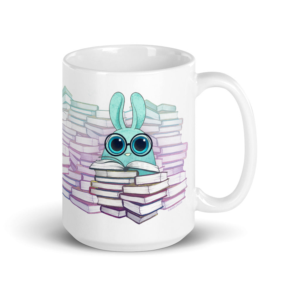 Introducing the So Many Books Mug by Bindlewood Shop: a white ceramic mug showcasing an adorable, cartoon-style turquoise creature with large eyes nestled among piles of books. The creature is depicted enjoying a book within a backdrop of soothing pastel gradients. This microwave and dishwasher-safe mug is an ideal choice for any enthusiastic book lover.